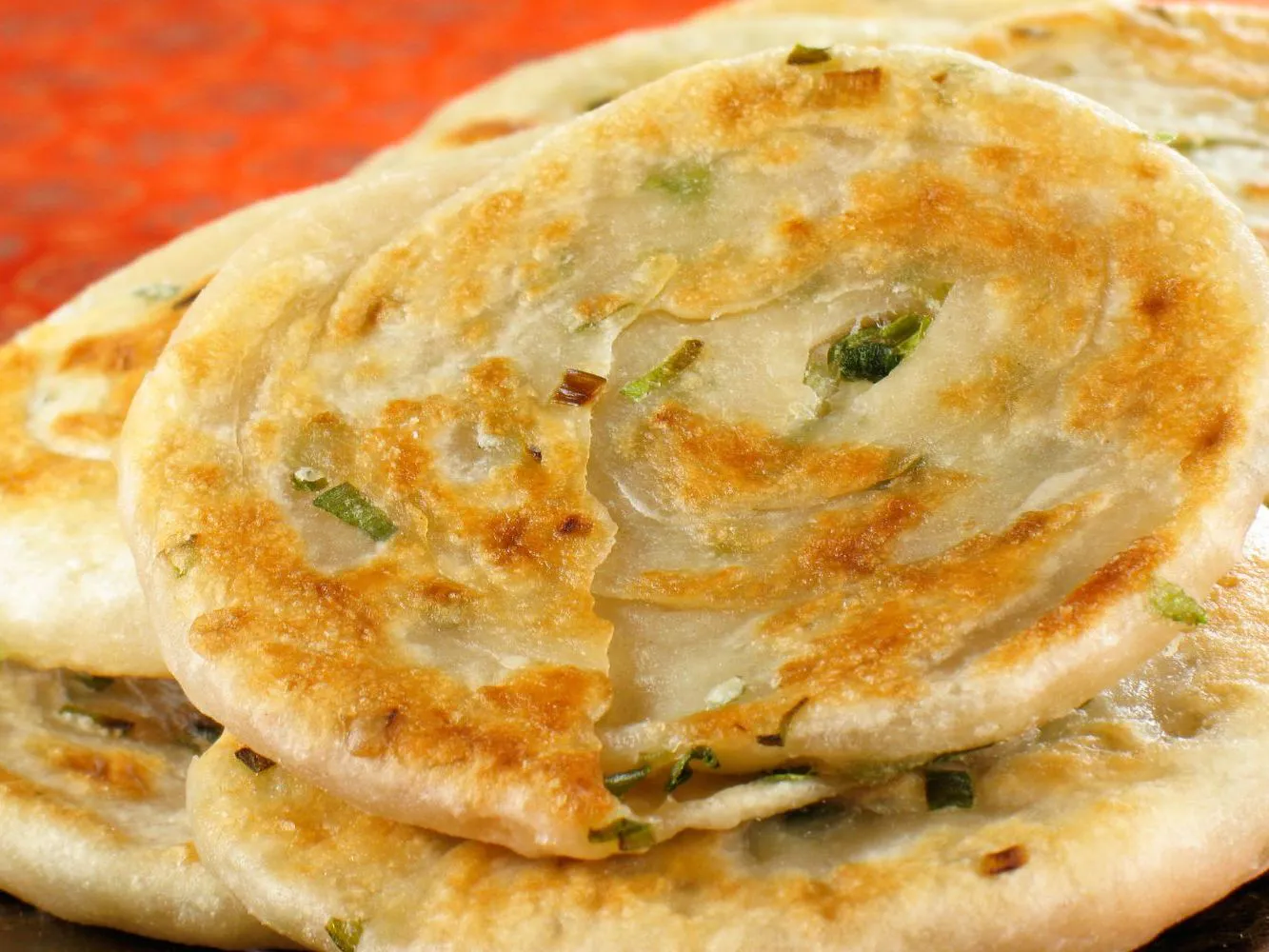 Thin layered pan-fried scallion cakes with golden brown crispy edges at Authentic Yongtai Scallion Pie & Shi Wei BBQ, a Chinese Restaurant in Brooklyn