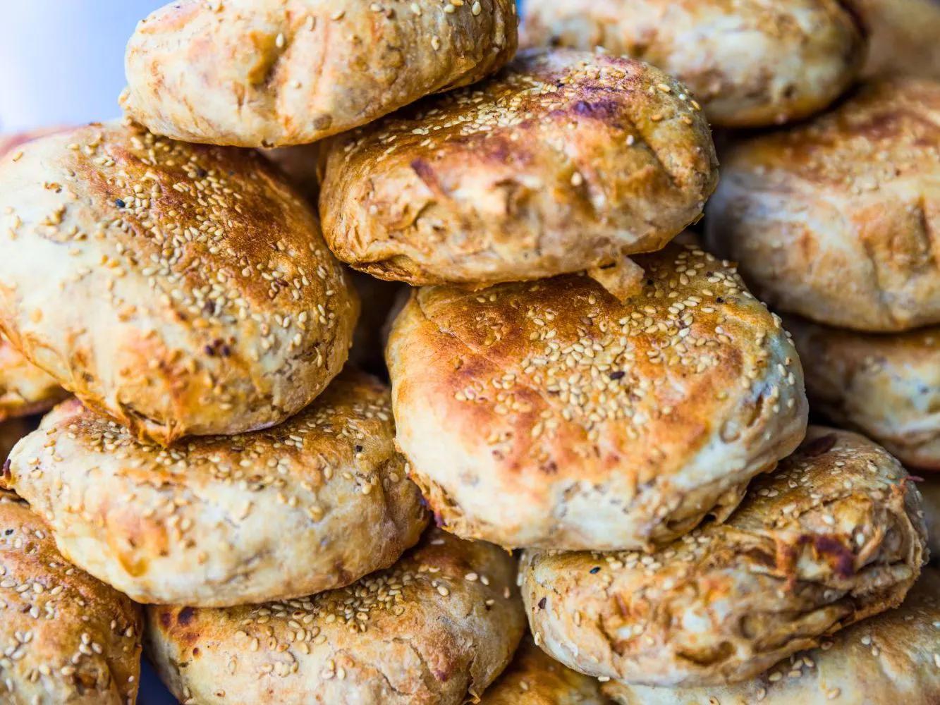 Stacked golden sesame baked sesame buns with crispy layered crust at Authentic Yongtai Scallion Pie & Shi Wei BBQ, a Chinese Restaurant in Brooklyn