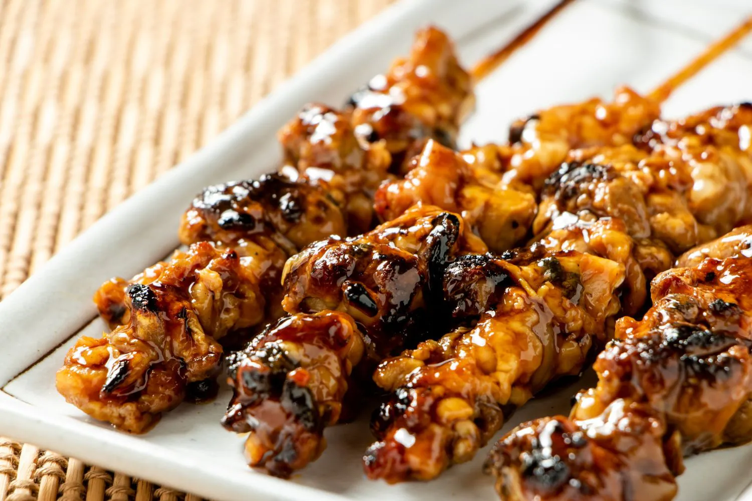Charred teriyaki chicken thigh skewers coated with glossy sweet sauce at Authentic Yongtai Scallion Pie & Shi Wei BBQ, a Chinese Restaurant in Brooklyn